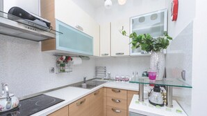 Moderni keittiö, jossa on sisäänrakennettu liesi, mikroaaltouuni ja lasitasoinen keittiösaareke.