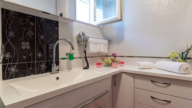 A bathroom with a white sink, a mirror, a towel rack, and a window. - Apartment Viva la Vita (Konavle)