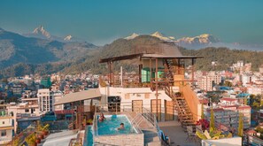 A rooftop pool with a view of a city and mountains. - Hotel Shaara (Pokhara)