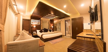 Una habitación de hotel con cama, escritorio, silla, televisión y baño.