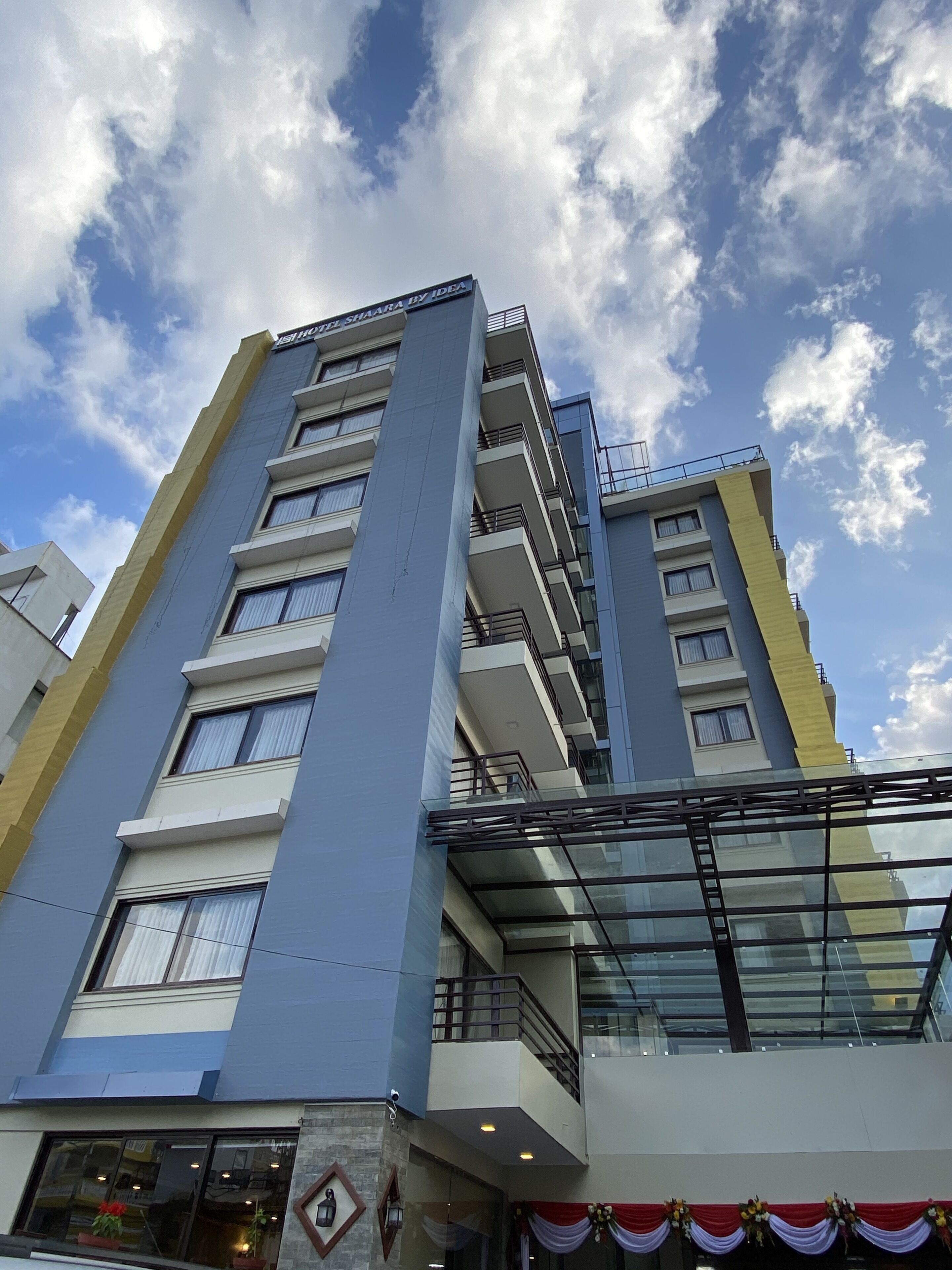A multi-story hotel with a modern design, featuring balconies and large windows.