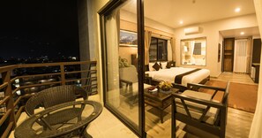 A hotel room with a balcony, a bed, a desk, and a chair. - Hotel Shaara (Pokhara)