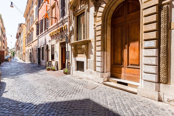 A cobblestone street with historic buildings, including a restaurant named "CRISCIOTTI" with outdoor seating.