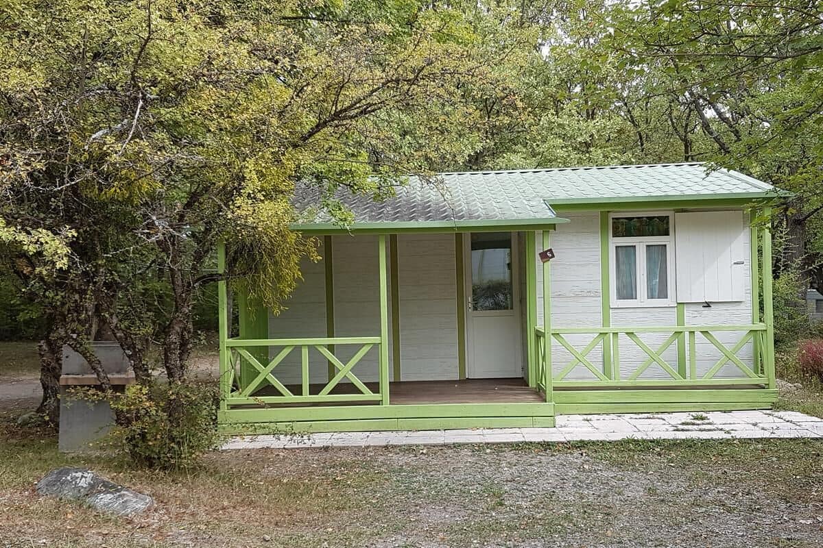 A small, single-story building with a green exterior and a porch.
