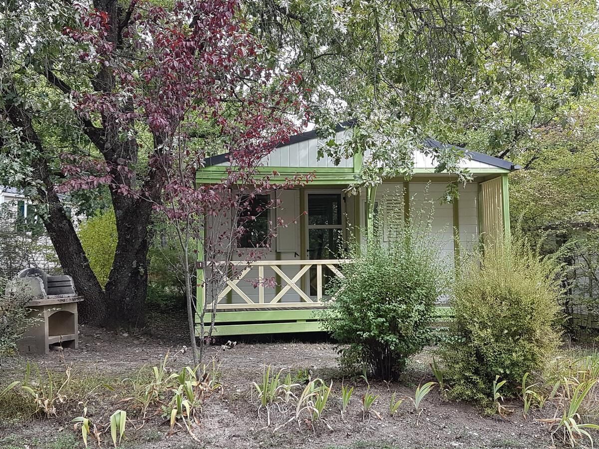 A small, single-story building with a green exterior and a porch.