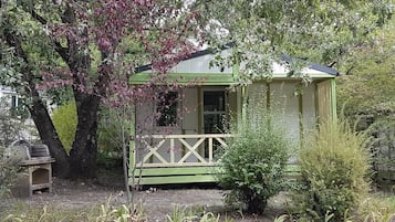 A small, single-story building with a green exterior and a porch.