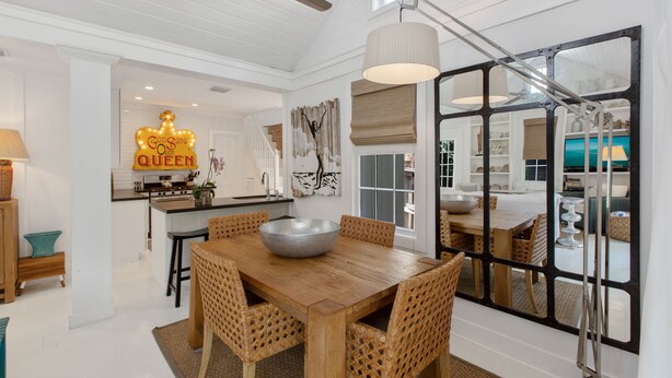 A dining area with a wooden table and wicker chairs, a large bowl centerpiece, and a ceiling fan. - QUEEN OF SOL ~ 3 Bed, 2 Bath in Peaceful Neighborhood with Dip Pool! (Key West)