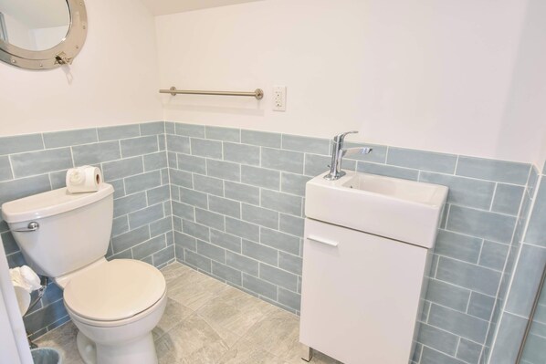 A bathroom with a toilet, sink, and a towel rack.