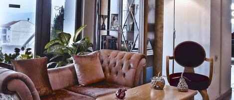 A cozy lobby with a plush sofa, a wooden coffee table, and a decorative cabinet.