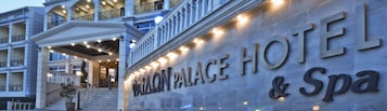 Exterior del Hotel & Spa Palamon Palace, con una entrada imponente, varios balcones y fachada bien iluminada.