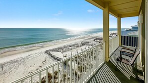Un balcon avec vue sur une plage et l’océan.