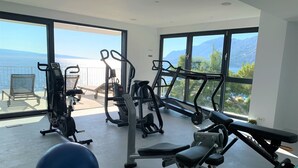 A home gym with exercise equipment and large windows offering ocean views. - Luxury villa Colomba in Brela, seafront (Brela)