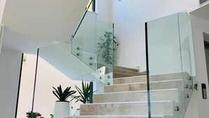A modern staircase with glass railings and marble steps, leading to an upper floor. - Luxury villa Colomba in Brela, seafront (Brela)