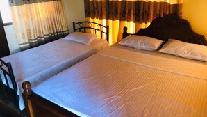 Un lit double avec une tête de lit en bois et un couvre-lit blanc.