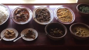 Une table où l’on trouve divers plats, notamment du riz, des plats à base de viande et des légumes.
