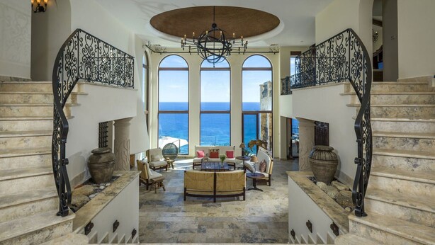A grand staircase with ornate black railings leading to a balcony overlooking the sea. - Villa in San Jose del Cabo 1023 (San José del Cabo)