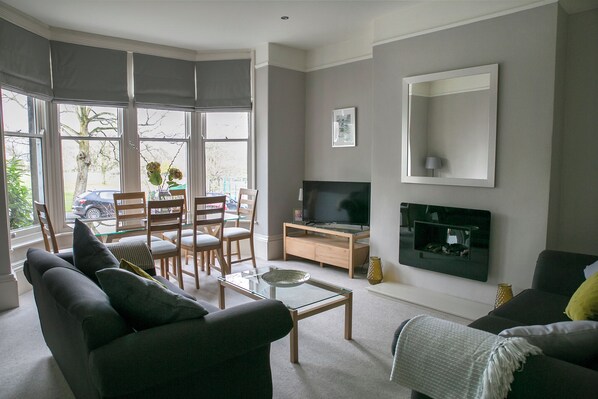 Relax in this spacious living room with a sofa, armchairs, and dining area, perfect for socializing or meals.