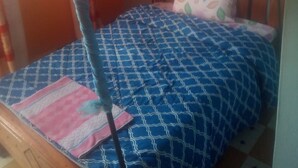 A single bed with a canopy, a patterned bedspread, and a pillow with a leaf design. - Kimbo Pefa Guest House (Ruiru)