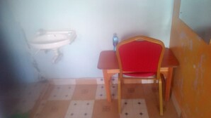 A small room with a sink, a chair, and a table. - Kimbo Pefa Guest House (Ruiru)