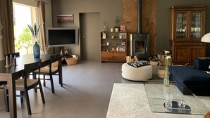 Una sala moderna con comedor, chimenea y televisor.