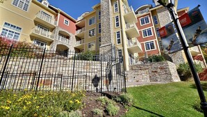 A multi-story building with balconies, a stone staircase, and a metal fence. - Bondurant by Tremblant Platinum (Mont-Tremblant)
