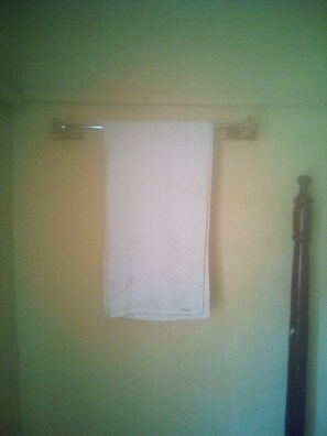 A bathroom with a white towel hanging on a towel rack. - Maleck Guest Rooms (Ruiru)