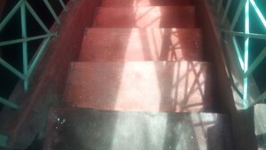 A staircase with metal railings and a red carpet. - Maleck Guest Rooms (Ruiru)