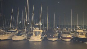 A marina at night with several boats docked.