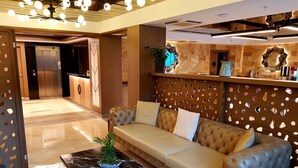 A modern lobby with a leather sofa, a marble coffee table, and a reception desk. - My Garden Hotel (Istanbul)