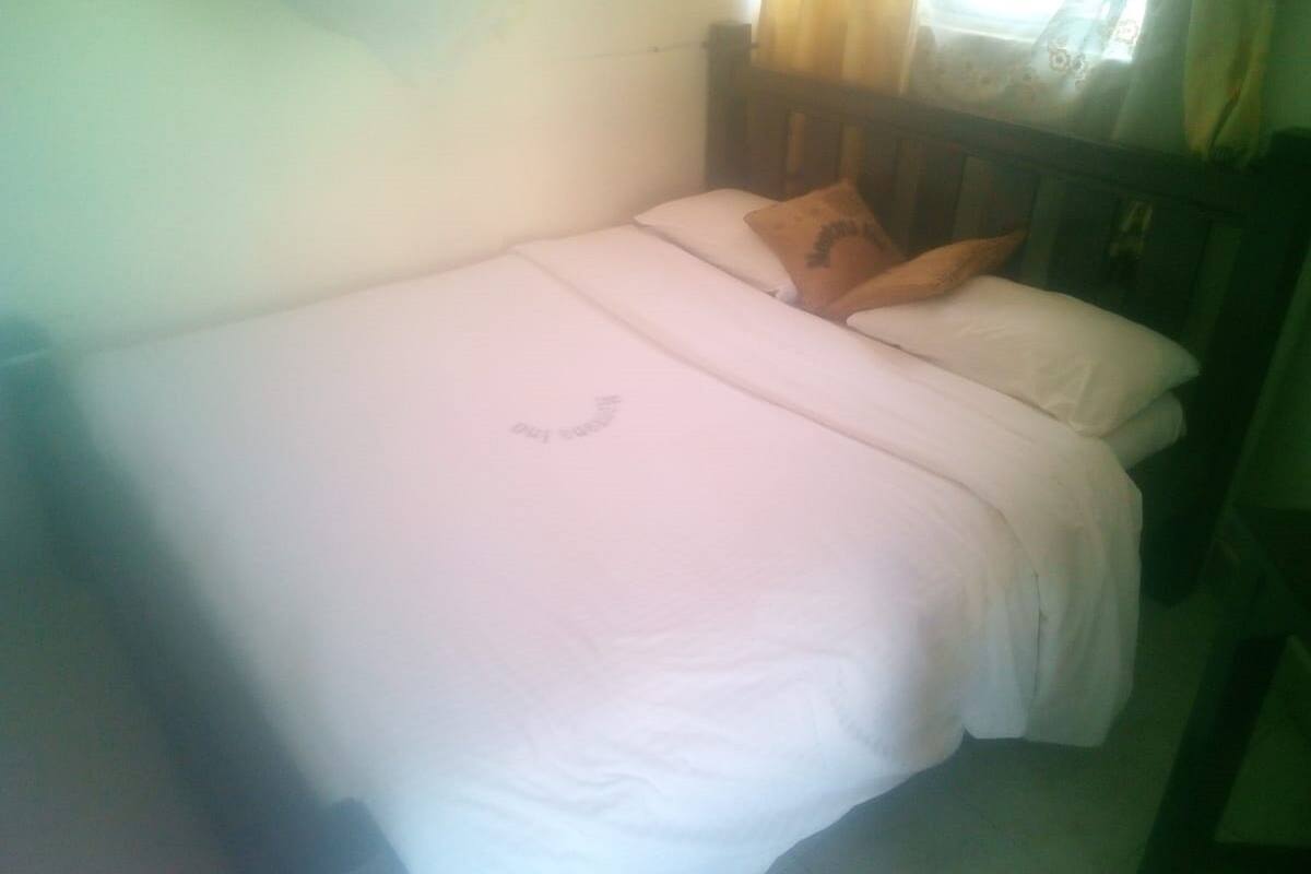 A single bed with white bedding and a wooden headboard.