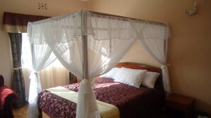 Un dormitorio con cama con dosel, una mesita de noche y un tocador.