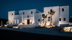 A modern white building with a symmetrical facade, multiple windows, and a central entrance. - Koukoumi Vegan Boutique Hotel (Mykonos)