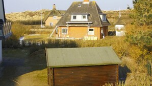 A house with a sloped roof, a chimney, and a small attached structure. - Vacation apartment Kiekin - Kiekut (Wenningstedt-Braderup (Sylt))