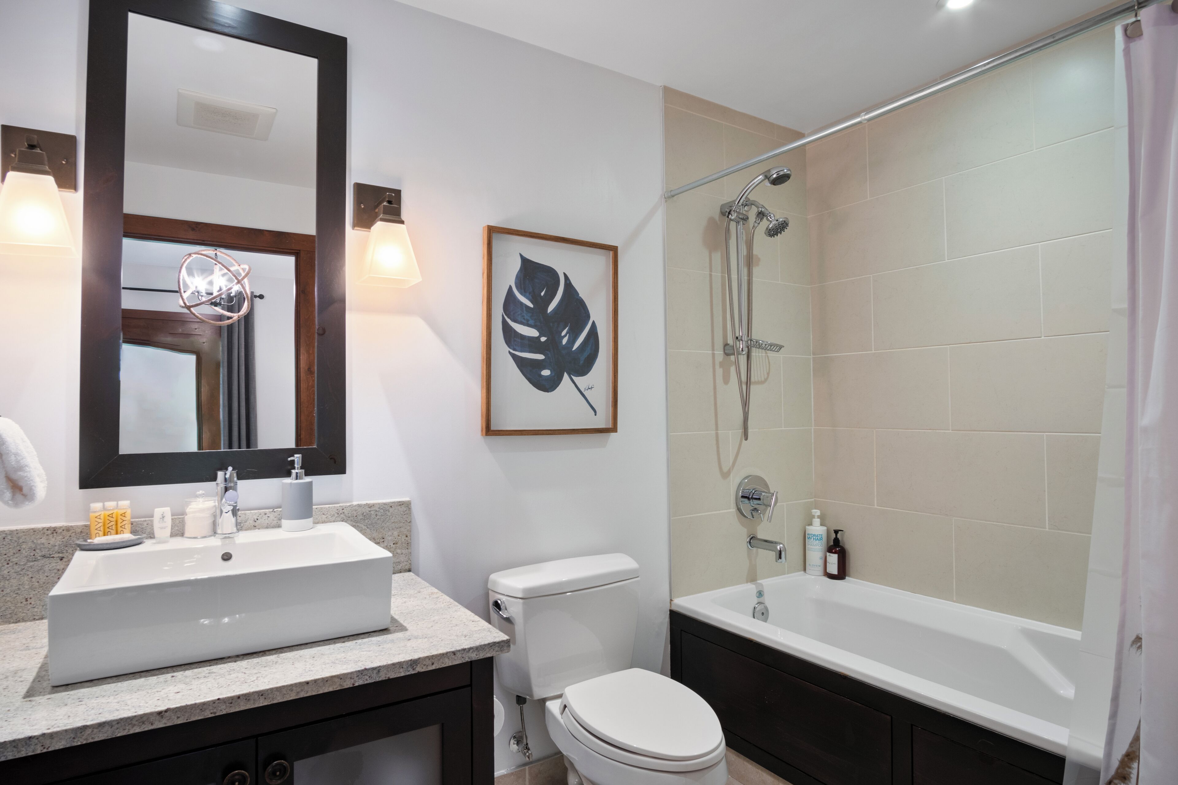 A modern bathroom with a large sink, toilet, and bathtub.