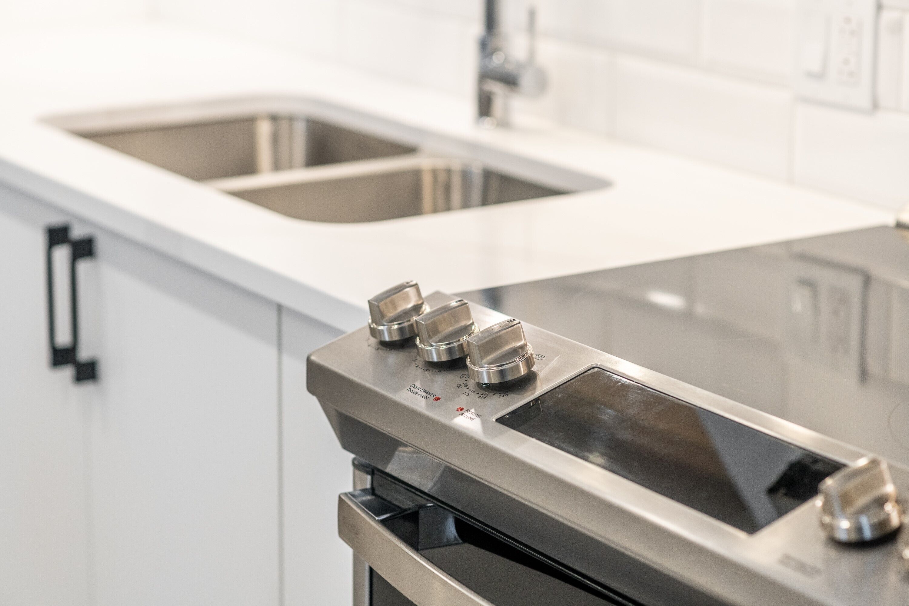 A modern kitchen with stainless steel appliances, a double sink, and a built-in oven.