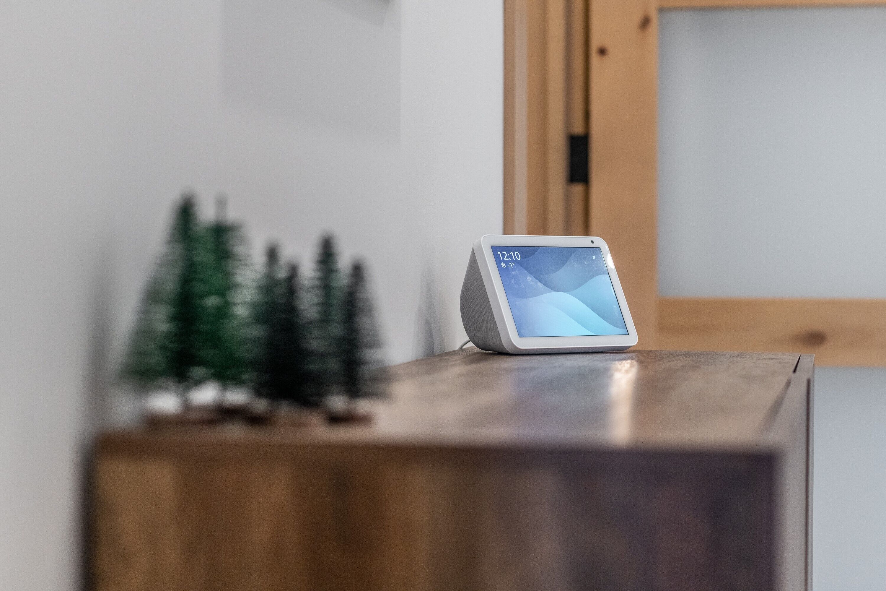 Une horloge numérique posée sur une surface en bois, avec un arrière-plan flou.