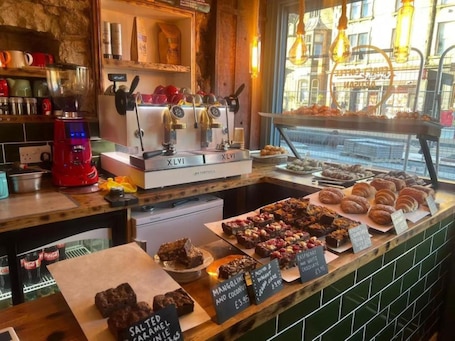 A bakery counter with various baked goods and a coffee machine.