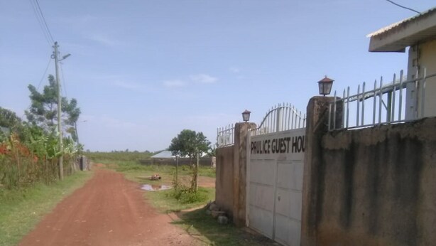 A rural road leading to a gated property labeled "PRULICE GUEST HOUSE". - Paulice Guest House (Kisumu)