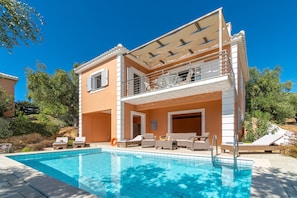 A two-story house with a swimming pool, outdoor seating, and a covered balcony. - Schiza Houses (Pylos-Nestoras)