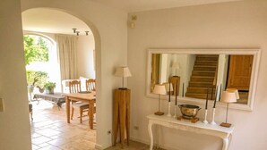 A hallway with a tiled floor, a wooden dining table with chairs, a white console table with lamps, and a mirror above it. - Guest house beautiful historic square farm 🎯 in Ranst (Broechem Antwerp)