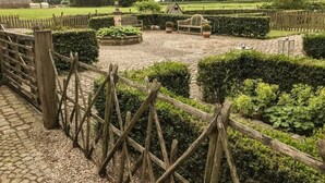 A garden with a gravel path, wooden fence, and neatly trimmed hedges. - Guest house beautiful historic square farm 🎯 in Ranst (Broechem Antwerp)