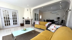 Ein Wohnzimmer mit einer Couch, einem Couchtisch und einem Kamin.
