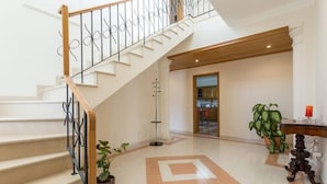 Eine Treppe mit Holzwahnschrank und schwarzen Metallspindeln, die zu einer oberen Etage führt.