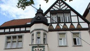 A traditional European hotel with a corner turret, multiple windows, and outdoor seating. - Hotel Drei Kronen (Lippstadt)