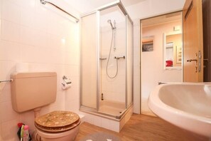 A bathroom with a toilet, shower, and bathtub.