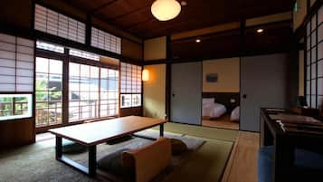 Una habitación japonesa tradicional con suelo de tatami, una mesa baja y puertas correderas.