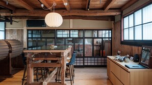 Una cocina rústica con vigas de madera, un ventanal grande y una lámpara colgante.