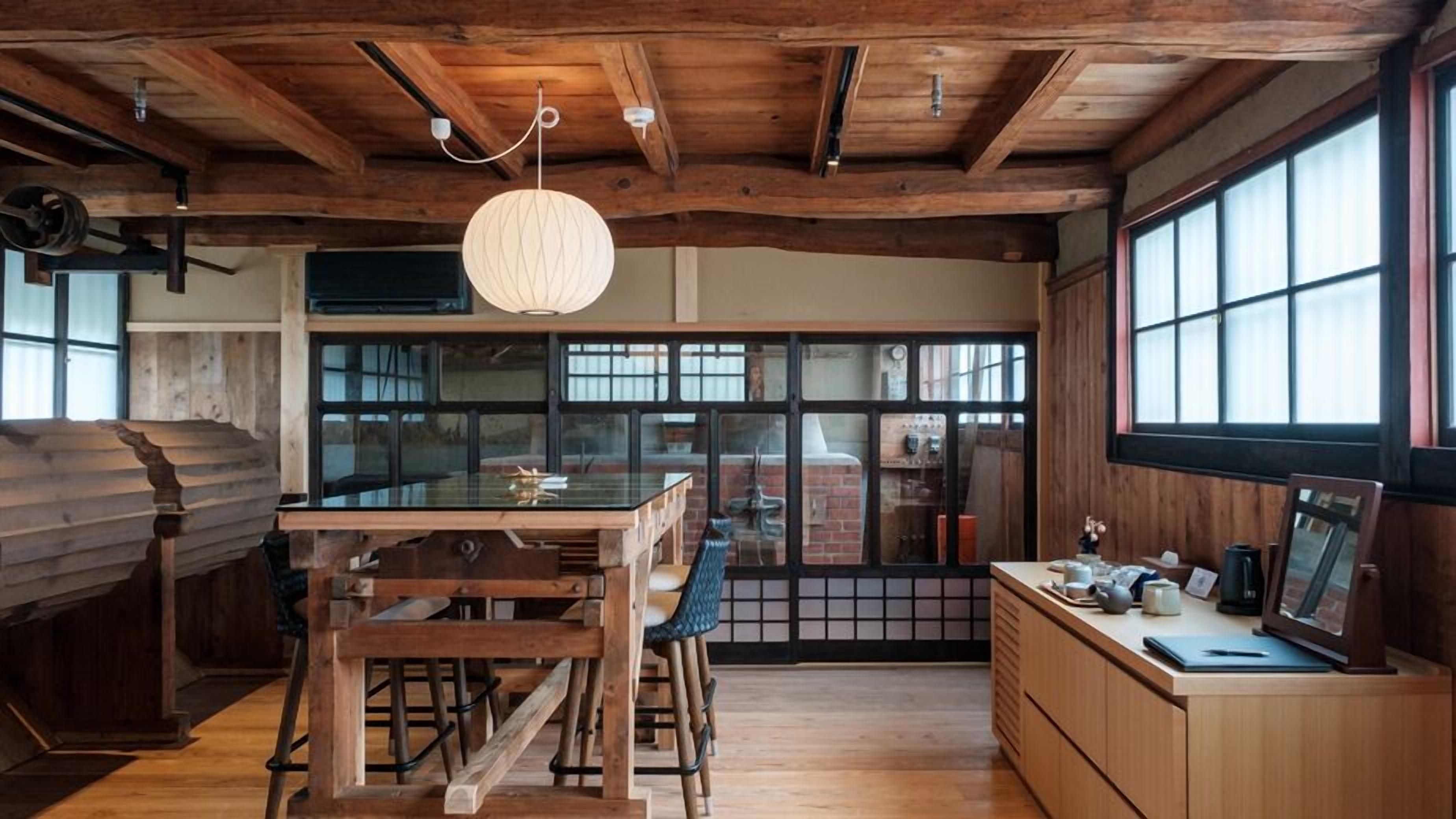 Una cucina rustica con travi in legno, un'ampia finestra e un lampadario a sospensione.