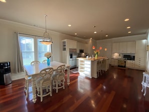 Enjoy meals in this well-equipped kitchen with a central island, dining table, and modern appliances.