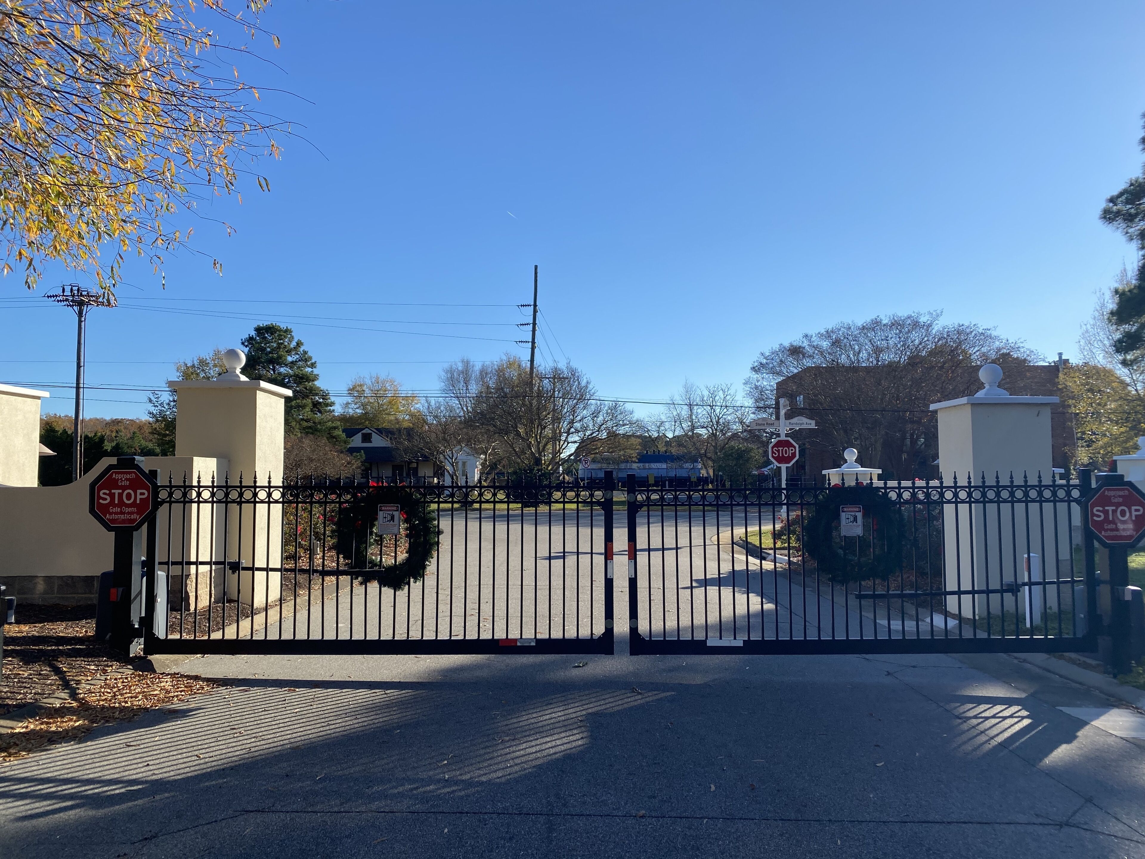 A gated entrance with a stop sign and a sign indicating the gate opens automatically.
